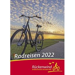 Titelbild des Rückenwind Radreisen Katalogs 2022 mit einem Fahrrad im Sonnenuntergang vor bewölktem Himmel über einem Küstenweg.