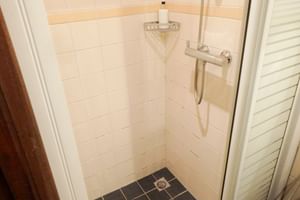 Moderne Dusche mit weißen U-Bahn-Fliesen, Handbrause, Eckregal und dunklen Bodenfliesen im SIMMER FAN FRYSLÂN Bad.