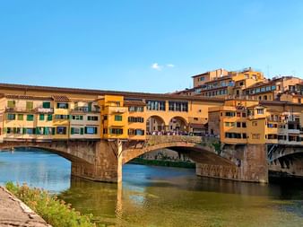 Ponte Vecchio Brücke in Florenz, Toskana Historische Ponte Vecchio Brücke in Florenz über den Arno mit bunten mittelalterlichen Gebäuden und Geschäften an den Seiten.