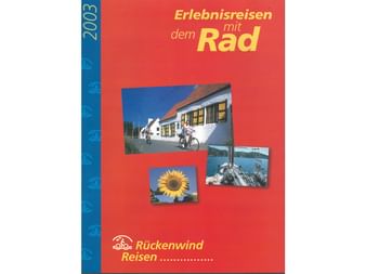 Titelseite des Rückenwind Radreisen Katalogs 2003 mit rotem Hintergrund. Zeigt drei Fotos: Radfahrer vor weißem Gebäude, Sonnenblume und Küstenszene.
