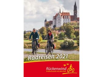 Cover des Rückenwind Radreisen Katalogs 2021 mit zwei Radfahrern in ländlicher Umgebung und historischem Schloss auf Hügel im Hintergrund.