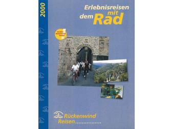 Titelseite des Rückenwind Radreisen Katalogs 2000 mit Radfahrern durch einen Steinbogen und malerischen Bergansichten.