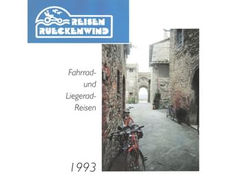 Titelseite des Rückenwind Radreisen-Katalogs 1993 mit einem Fahrrad in einer engen mittelalterlichen Gasse mit Steinmauern und Torbogen.